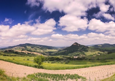 Wolkiges Panorama von toskanischem Hügelland mit Anbaufläche im Vordergrund, 180 Grad